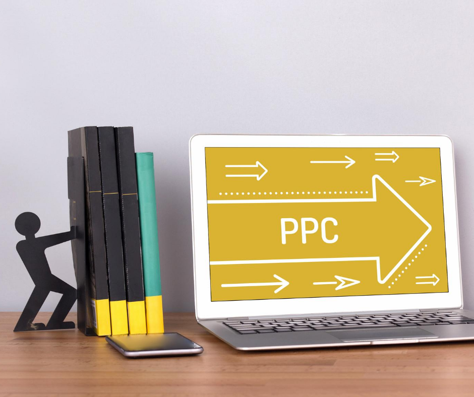 PPC text on laptop, books on bookstand shaped like a person